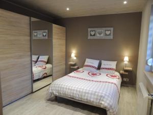 a bedroom with a large bed and a mirror at Gîte ESPERANZA SPA et SAUNA in Hazelbourg