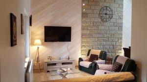 Una televisión o centro de entretenimiento en Gîte ESPERANZA SPA et SAUNA