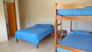 2 literas con sábanas azules en una habitación en Casamar, en Máncora
