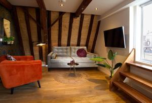 ein Wohnzimmer mit einem Sofa und einem TV in der Unterkunft Haarlem Hotel Suites in Haarlem