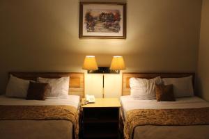 two beds in a hotel room with two lamps at Hotel Mediterraneo Plaza in San Salvador +49 photos
