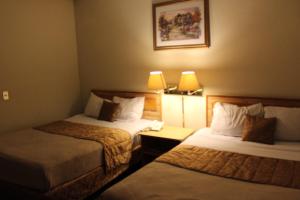a hotel room with two beds and two lamps at Hotel Mediterraneo Plaza in San Salvador