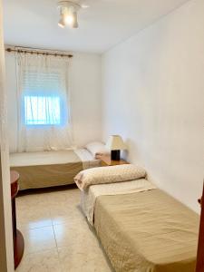 a bedroom with two beds and a window at APARTAMENTO - WIFI FREE - PISCINA 250 M PLAYA in Cambrils
