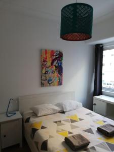 1 dormitorio con 1 cama y una pintura en la pared en BED&SHOWER Moscavide -Self Check-In, en Lisboa