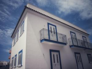 兰佩杜萨Appartamenti Alba e Tramonto的白色的建筑,设有蓝色的窗户和阳台