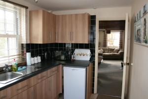 a kitchen with wooden cabinets and a white refrigerator at Honeysuckle in Crayke YO61 4TE in York