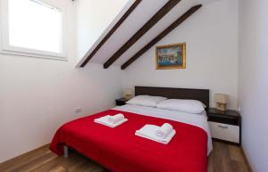 a bedroom with a red bed with two white towels on it at Villa Mia in Dubrovnik