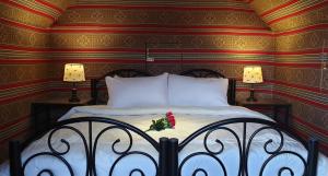 a bedroom with a bed with a flower on it at Real Bedouin Experience Tours & Camp in Wadi Rum