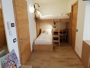 Habitación pequeña con cama y escritorio. en LE 4 STAGIONI en Cavedago