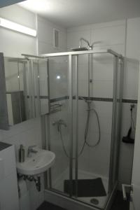 een badkamer met een douche en een wastafel bij Kiel - Schilksee Ferienwohnung Kasing inkl WLAN bezogene Betten und Handtücher in Schilksee