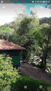 a green building with trees in the background at venha curtir a natureza in Nova Friburgo