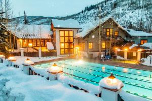 a swimming pool covered in snow in front of a house at Vail Racquet Club Mountain Resort in Vail