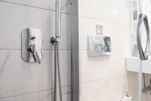 a shower in a bathroom with a phone on the wall at Fix Divine Apartment in Athens