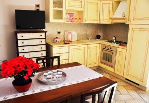 una cucina con tavolo e fiori rossi di SCHITO 114 Apartments a Treia