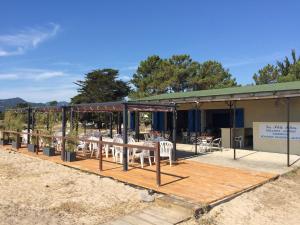 un bâtiment avec une table et des chaises sur une terrasse dans l'établissement Village Del Mar - Corse, à Solaro