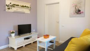een woonkamer met een tv op een witte kast bij Welcome Apartment in Timişoara