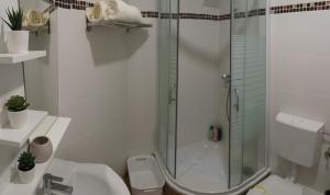 een badkamer met douche, toilet en wastafel bij Welcome Apartment in Timişoara +12 foto's