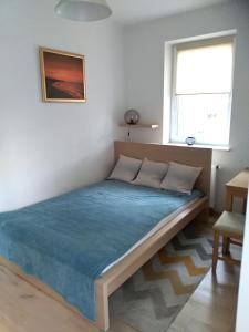 duże łóżko w pokoju z oknem w obiekcie Apartamenty Willa Nawigator w mieście Gdynia