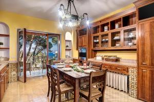 Una cocina con una mesa de madera y un comedor. en GOCCE VILLAS - El Royale Suites Sorrento, en Sorrento