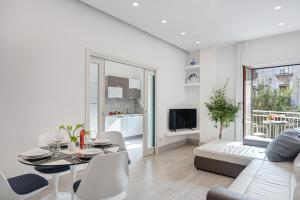 sala de estar blanca con mesa y sofá en GOCCE VILLAS - El Royale Suites Sorrento, en Sorrento