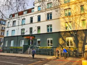 ein Gebäude auf einer Straße mit Leuten, die davor laufen in der Unterkunft Euston Square Hotel in London