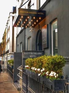 un edificio con una señal para la entrada a un hotel de la plaza de la moda en Euston Square Hotel, en Londres