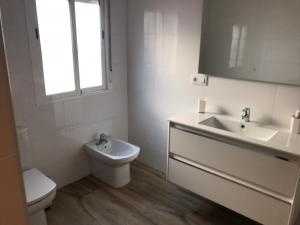 a white bathroom with a sink and a toilet at Casa patio ribera de córdoba in Córdoba +13 photos
