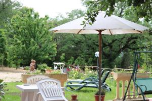 a table with an umbrella in a garden at Boscodisotto in Rapolano Terme