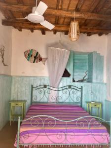 1 dormitorio con cama morada y techo en Casa Gianni Alicudi, en Alicudi