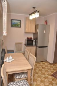 a kitchen and dining room with a table and a refrigerator at Apartament Pod Świerkami in Olecko