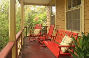 three red rocking chairs on the porch of a house at St. Francis Inn - Saint Augustine in Saint Augustine