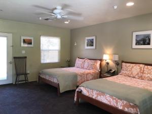 a bedroom with two beds and a ceiling fan at Queen's Inn By The River in Oakhurst