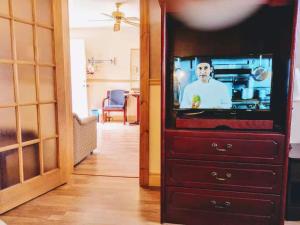 uma televisão numa cómoda numa sala de estar em Hotel Motel La Marquise em Sherbrooke