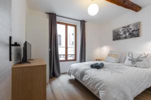 昂蒂布的住宿－Vieil Antibes Charming Guillaumont，一间卧室设有一张床、一台电视和一个窗口。