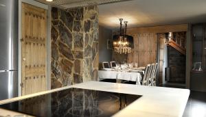 a dining room with a table and a stone wall at La Caseta de Queixans in Puigcerdà