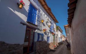 eine schmale Gasse mit blauen und weißen Gebäuden in der Unterkunft Casona les Pleiades in Cusco