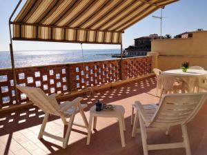 a patio with a table and chairs and the ocean at On the sea in Santa Marinella