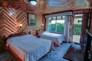 a bedroom with two beds and a window at Mar Inn Costa Rica in Monteverde Costa Rica