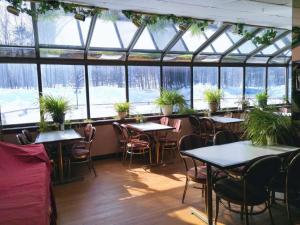 un restaurant avec des tables, des chaises et des plantes en pot dans l'établissement Hotel Motel La Marquise, à Sherbrooke