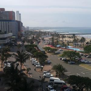 a parking lot with cars parked in a parking lot at Durban Beachfront OceanSeaside Self Catering Apartments in Durban