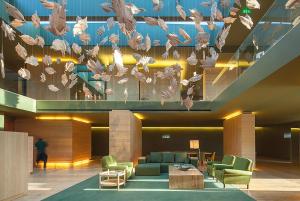 een lobby met stoelen en tafels en een kroonluchter bij Monverde - Wine Experience Hotel - by Unlock Hotels in Amarante