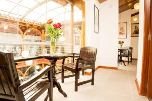 a dining room with a table with a vase of flowers at Hotel San Pedro Plaza in Cusco