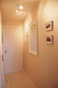 un pasillo con una puerta y cuadros en la pared en Appartement Vivacances côte d'Opale (Ste-Cécile), en Camiers
