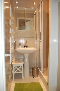 a bathroom with a sink and a shower with a mirror at Appartement Vivacances côte d'Opale (Ste-Cécile) in Camiers