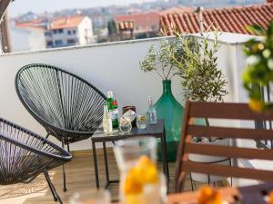 a table with two chairs and a green vase on a balcony at Dream Istria Holiday in Poreč