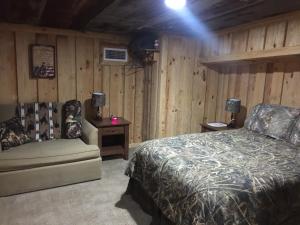 een slaapkamer met een bed en een stoel in een kamer bij Red Fern Plantation Lodge in Statesboro