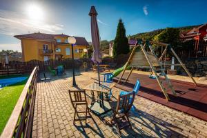 un parque infantil con mesa, sillas y sombrilla en Apartamentos Cudillero, en Cudillero