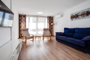 a living room with a blue couch and chairs at Vistas al Mar in Alicante