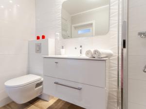 biała łazienka z toaletą i umywalką w obiekcie Apartament Rybacka 12A/68, Kołobrzeg w Kołobrzegu +12 zdjęć