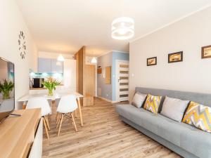 salon i kuchnia z kanapą i stołem w obiekcie Apartament Rybacka 12A/68, Kołobrzeg w Kołobrzegu